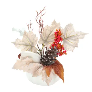 Citrouille décorative blanche avec feuilles d'automne, baies rouges et pommes de pin