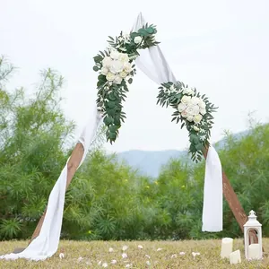 Artificial white rose flower swags with white drapes on a wooden wedding arch