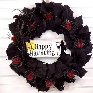 Halloween wreath with black maple leaves, spiders, and Happy Haunting wooden sign