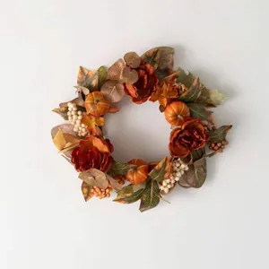 Détail d'une couronne d'automne avec pivoines, citrouilles et feuilles d'érable sur fond blanc