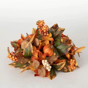 Détail d'une couronne d'automne avec citrouilles, baies artificielles et feuillage texturé
