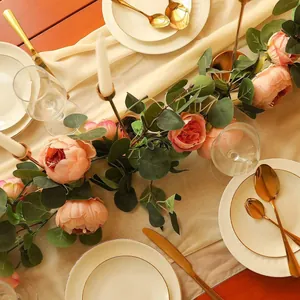 Close-up of pink silk peony and eucalyptus garland on a luxury wedding table setting