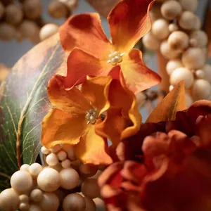 Vue macro de pivoines en soie et baies ivoire dans une couronne de porte d'automne