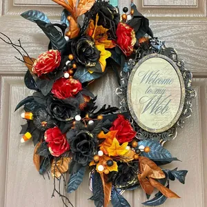 Gotischer Halloween Kranz mit schwarzen Rosen und Spinnen auf dunklem Holztür Dekor