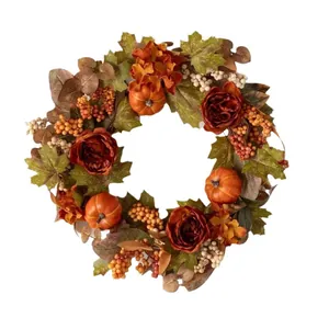 Couronne d'automne avec citrouilles, pivoines rouges et feuilles d'érable pour décor