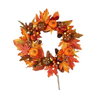 Close-up of autumn wreath with maple leaves, pumpkins, pinecones and berries for decor