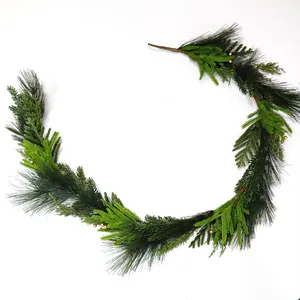 Detailed texture of artificial Christmas garland with mixed pine needles and gold berries