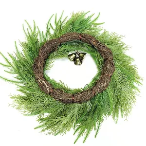 Christmas pine needle wreath with rustic vines and three bronze bells on white background