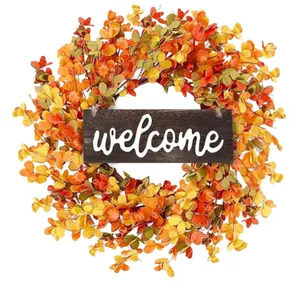 Autumn harvest wreath with orange leaves, mini pumpkins, berries and a welcome wood sign