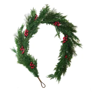 Close-up of artificial pine needles with bright red berries and pine cones for Christmas decor