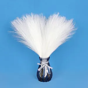 Detailed close-up of fluffy white artificial pampas grass in a faceted grey glass vase