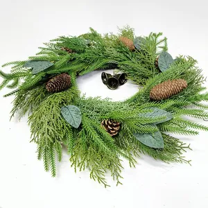 Christmas pine needle wreath with natural pine cones and three bronze metal bells on white