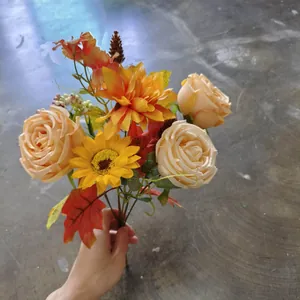 Handheld autumn bouquet with orange roses, yellow sunflowers and red maple leaves