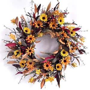 Détails d'une couronne d'automne avec tournesols, baies rouges et feuilles d'érable colorées