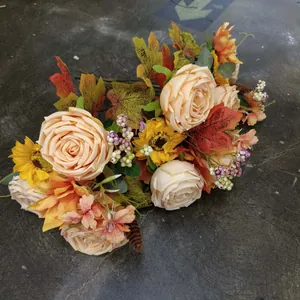 Detailed close-up of autumn bouquet with sunflowers, maple leaves, and pine cones