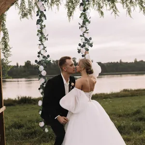 Artificial white roses and eucalyptus garland used as decoration on a lakefront swing