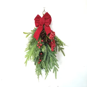 Detail of flocked Christmas swag with red berries, pine cones and a velvet bow