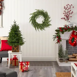 Lush green PE soft pine wreath with needles hanging on a white wall above a festive fireplace