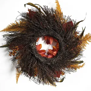Frontansicht eines herbstlichen Erntekranzes mit orangefarbenen Kürbissen und Beeren