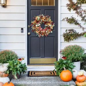 Artificial fall wreath with lamb ear leaves and berries on a black front door
