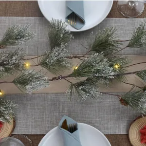 Artificial snowy pine garland with LED lights and pinecones for Christmas table decor