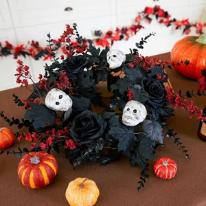 Halloween wreath with black roses maple leaves and three white skulls on a brown table