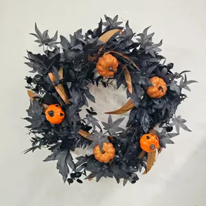 Detail of Halloween wreath with black maple leaves, orange pumpkins and glitter accents