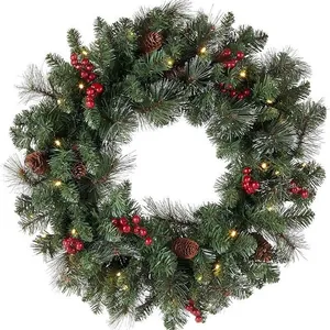Christmas wreath with pine needles, red berries, cones and warm LED lights on white background