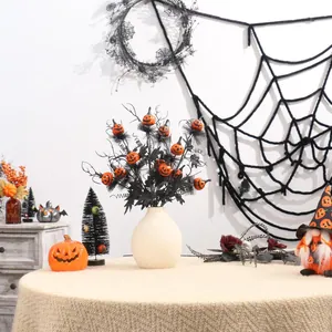 Gros plan de branches noires d'Halloween avec citrouilles dans un vase blanc