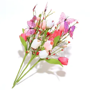 Detail of faux tulips with decorative purple butterflies and berries on white backdrop