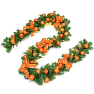Detail of 2.7m Christmas garland with green pine needles and orange festive ornaments