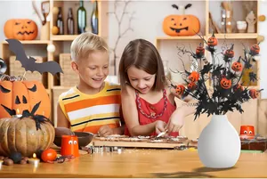 Branche d'Halloween avec mini citrouilles dans un vase blanc pour décor de fête