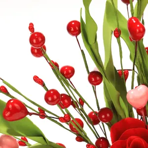 Detail of red and pink heart berries with green leaves on artificial festive stems