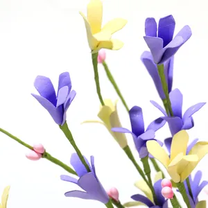 Macro shot of artificial Easter flower stems with purple and yellow petals and green stems
