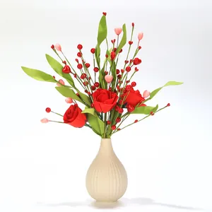 Detail of red silk roses with heart-shaped berries in a white ribbed ceramic vase