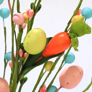 Détail de branches décoratives de Pâques avec œufs colorés et carottes artificielles