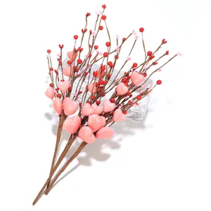 Nahaufnahme von drei künstlichen Herzbeeren-Zweigen mit rosa Herzen für die Deko