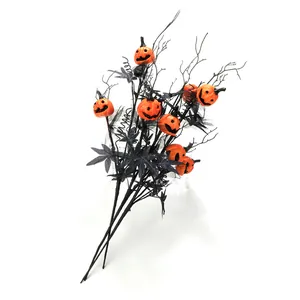 Halloween decorative branch with black maple leaves and orange pumpkin skull jack-o'-lanterns