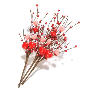 Detail von dekorativen Herz-Steckern mit roten Beeren für Valentinstag-Blumenarrangements