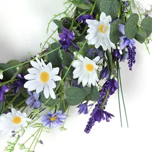 Close-up of artificial daisy wreath with lavender, eucalyptus leaves and rattan base