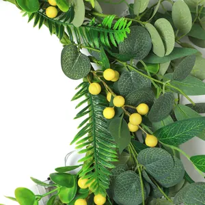 Detailed view of eucalyptus leaves and yellow berries wreath with LED light string