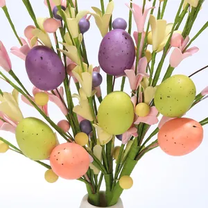 Close-up of Easter berry stems with colorful spotted eggs and spring wildflower buds