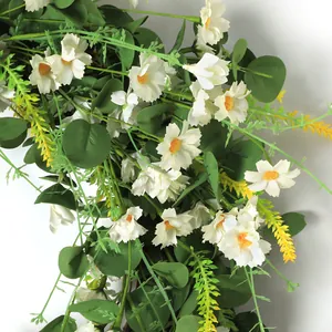 Macro detail of white faux daisies and green eucalyptus leaves for door wreaths