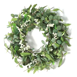 Close-up of artificial eucalyptus wreath with green leaves and white berries for home decor