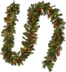 Detailed view of Christmas garland with pine cones, red berries and warm LED lights