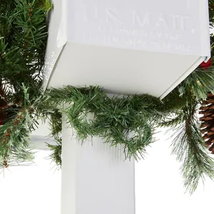Close-up of white Christmas mailbox with pine branches, pinecones and red berries
