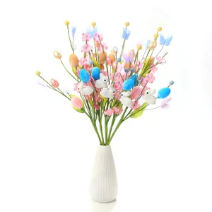 Easter floral bouquet with colorful eggs and rabbits in a white ceramic vase