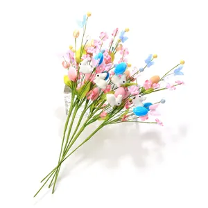 Easter decoration stems with colorful eggs, plush bunnies, and faux flowers on white backdrop