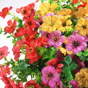 Close-up of vibrant artificial flowers with realistic petals and green leaves in a basket