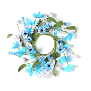Detalle de corona de vela de 30cm con flores artificiales azules y blancas pequeñas